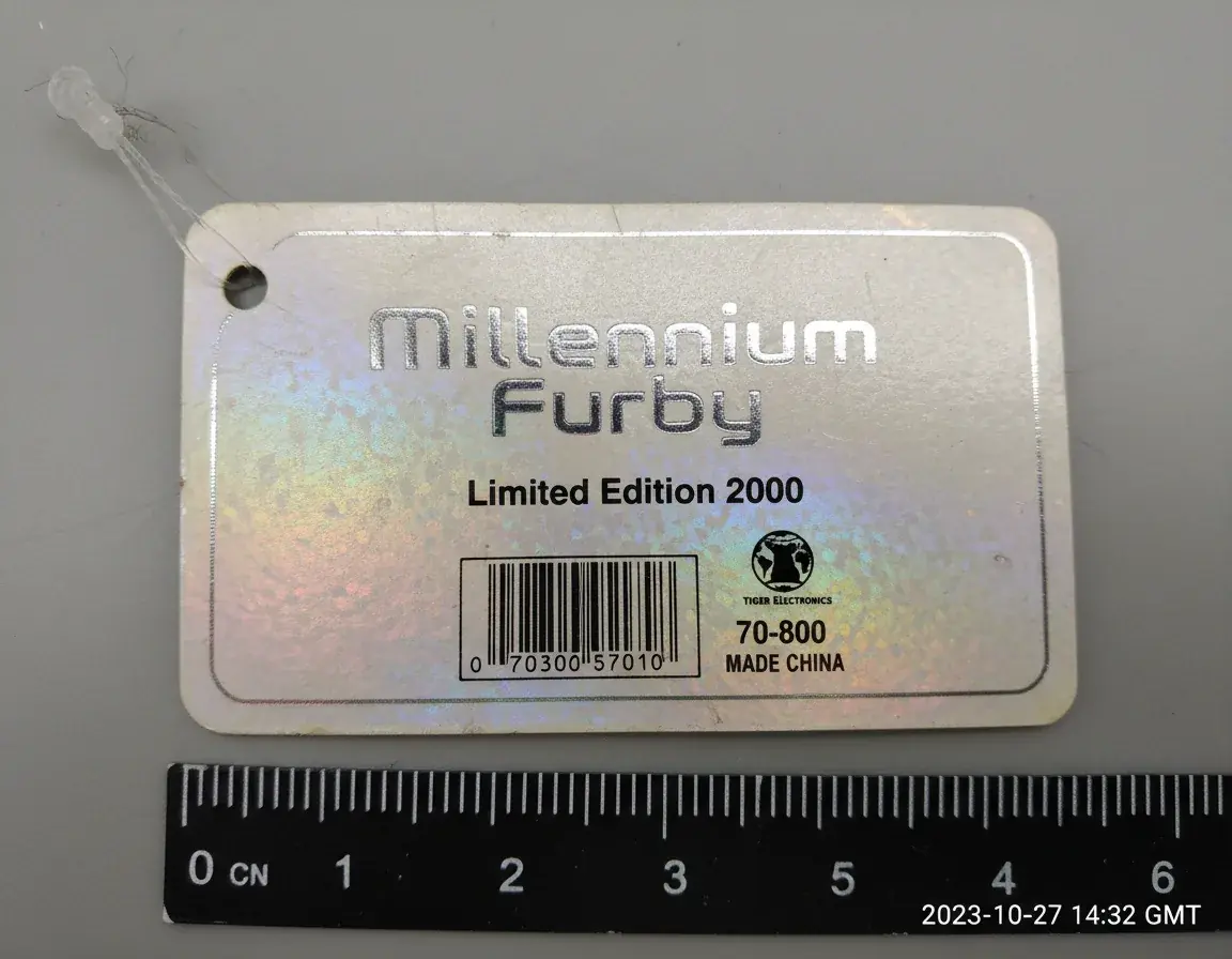 Close-up of a genuine Millennium Furby tag showing commemorative poem and production markings
