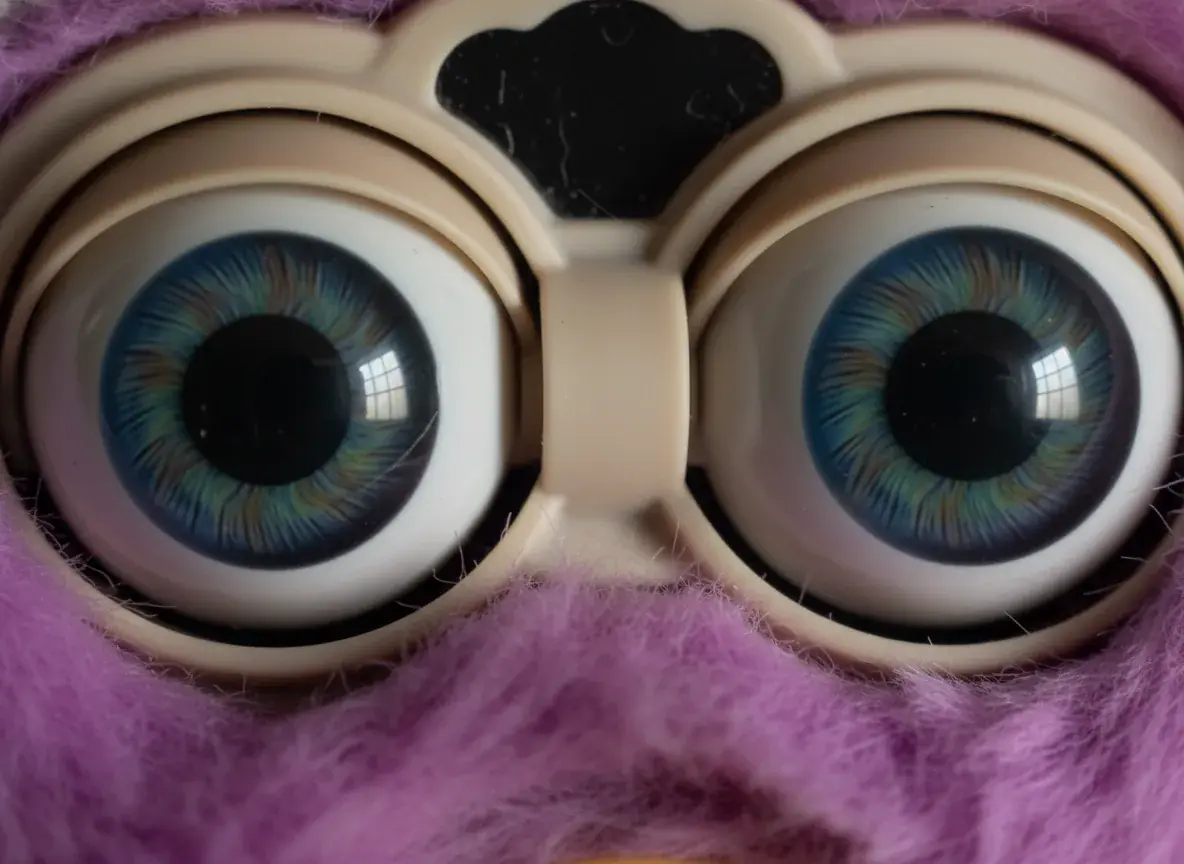 close-up of Furby eyes showing realistic glass-like appearance demonstrating uncanny valley